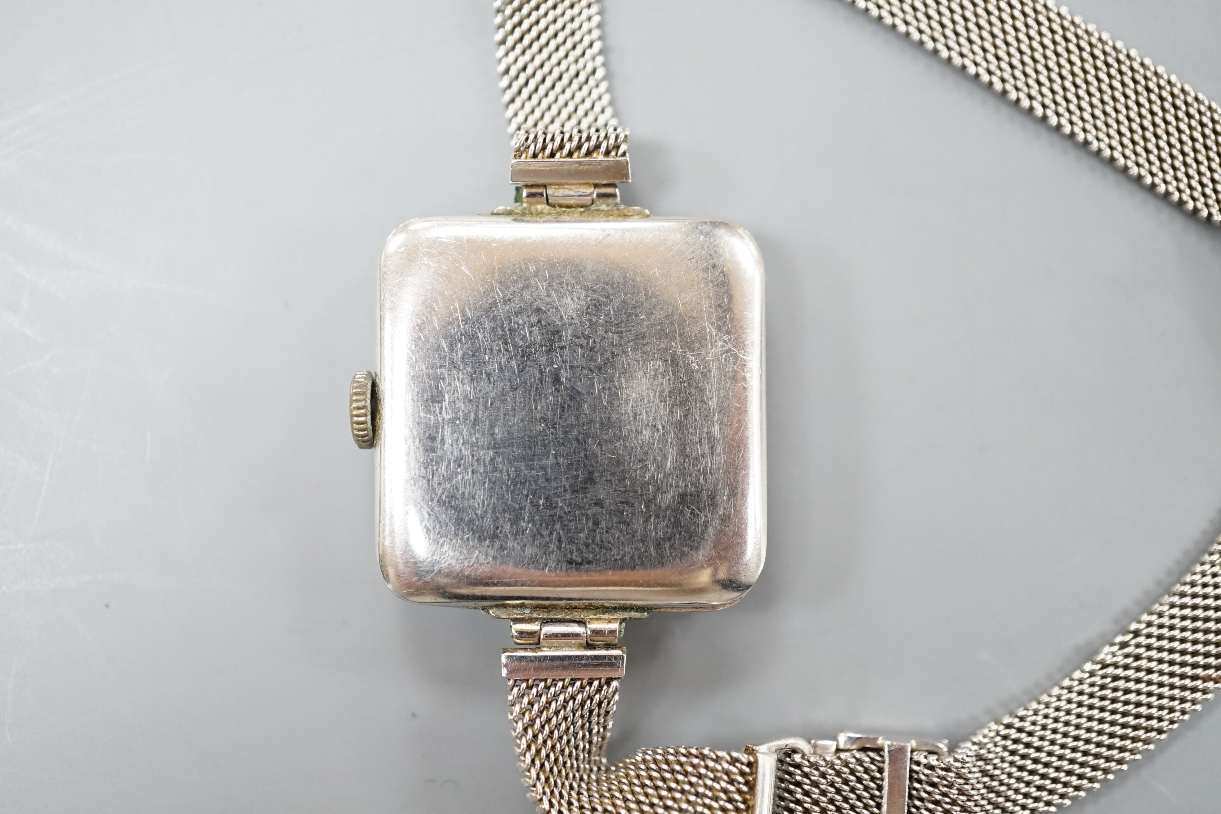 A lady's early 20th century white metal (stamped Plat) and diamond chip set manual wind cocktail watch, on a later 9ct white gold mesh link bracelet, gross 26.3 grams, (stone missing).